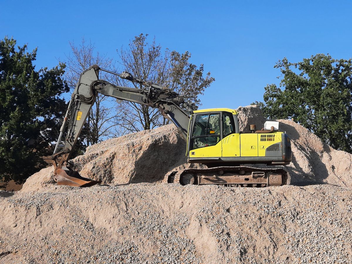 Excavator grading a gravel pad